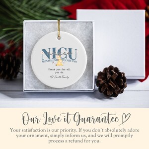 May include: A white ceramic bauble with a blue and white design that reads "NICU nurse NEONATAL INTENSIVE CARE UNIT". The bauble also features a small illustration of a nurse holding a baby. The text "Thank you for all you do. Smith Family" is printed on the bauble.