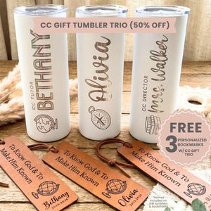 May include: Three white insulated tumblers with personalized names and designs, including a globe and compass. The text "CC GIFT TUMBLER TRIO (50% OFF)" is visible. Three brown leather bookmarks with the text "To Know God & To Make Him Known" are also present.