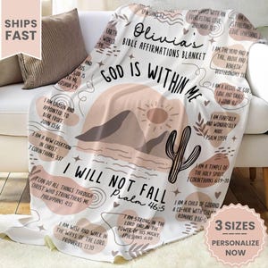 May include: A white throw blanket with a desert landscape design and inspirational bible verses. The blanket features a cactus, mountains, and a sun. The text includes "God is within me" and "I will not fall".