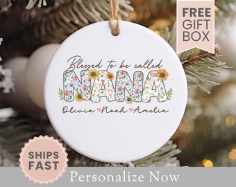 May include: White ceramic ornament with a floral design that says "Blessed to be called Nana" with the names Olivia, Noah, and Amelia underneath.