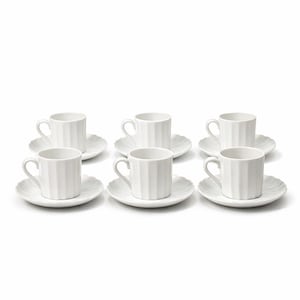 Könnte beinhalten: Ein Set aus sechs weißen Espressotassen und Untertassen aus Keramik. Jede Tasse hat ein geripptes Design und einen gebogenen Henkel. Die Untertassen haben einen gewellten Rand. Das Set steht auf einer weißen Oberfläche.