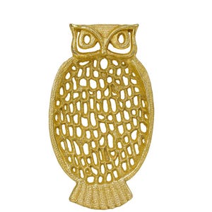 May include: A gold-colored, owl-shaped decorative tray. The tray features a detailed owl design with openwork detailing throughout the body. The owl has large eyes and a textured surface. The tray is made of metal and is suitable for home decor.