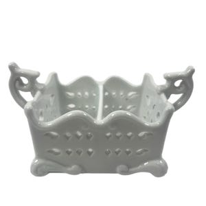 May include: White ceramic serving dish with two compartments and decorative cutouts. The dish has two handles on the sides and a scalloped edge.