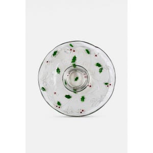 以下が含まれることがあります： 中央にディップボウルが付いた透明なガラス製のサービング皿。緑の葉と赤いベリーのホリーとベリーのデザインが特徴です。縁はスカラップエッジで、前菜や軽食の提供に適しています。
