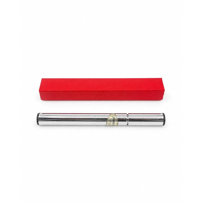 May include: A silver metal pen with black ends and a small label, presented with a bright red rectangular box. The pen is lying horizontally on a white background.