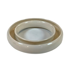 May include: Two nested, off-white ceramic bowls. The larger bowl has a wide, shallow base, and the smaller bowl sits inside, creating a layered effect. The bowls have a smooth, glossy finish, and are suitable for serving or display.