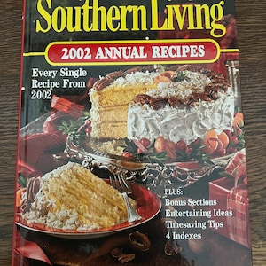 May include: A cookbook titled "Southern Living 2002 Annual Recipes" with a photo of a layered cake on the cover. The text "Every Single Recipe From 2002" is on the cover. The book also includes bonus sections, entertaining ideas, timesaving tips, and four indexes.