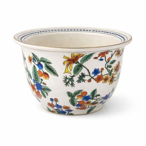 Könnte beinhalten: Ein weißer Keramik-Blumentopf mit einem Blumendesign mit orangefarbenen, blauen und gelben Blumen mit grünen Blättern. Der Rand hat ein blau-weißes Muster mit goldenem Rand.