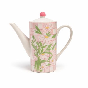 May include: A ceramic teapot with a white spout and handle, and a pink lid with a small pink knob. The body of the teapot is decorated with a pink and white checkered pattern and daisy floral design. The teapot is designed for serving tea.