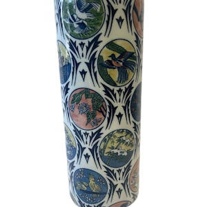 May include: A white ceramic vase with a cylindrical shape and a repeating pattern of blue, green, yellow, and pink circles featuring stylized birds and flowers.