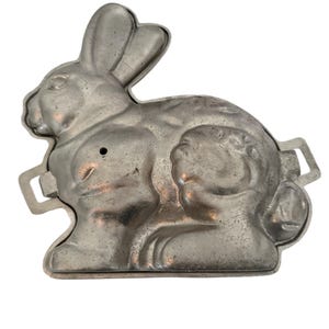 May include: Vintage aluminum bunny cake pan with two handles. The pan is designed to create a detailed bunny shape.