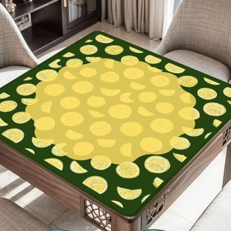 Pode incluir: Uma toalha de mesa quadrada com um design de lim&atilde;o. A capa tem uma borda verde escura com fatias de lim&atilde;o e um centro amarelo cheio de formas de lim&atilde;o. A mesa &eacute; de madeira e tem entalhes decorativos.