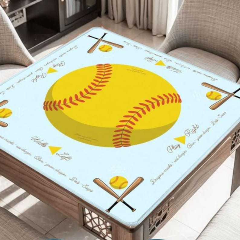 May include: A square table cover with a light blue background featuring a large yellow softball with red stitching. The design includes baseball bats, balls, and text that reads "Play Right" and "Walls Left".