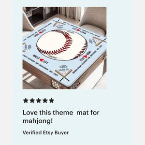 May include: A square light blue mahjong mat featuring a large central baseball graphic with red stitching. The mat includes printed text and illustrations of crossed baseball bats in each corner, with directional markers labeled PLAY RIGHT and WALLS LEFT.