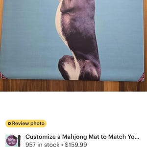 May include: Custom mahjong mat featuring a stylized dog illustration in a playful pose. The dog is primarily purple and white, set against a light blue background. The mat has a decorative border.
