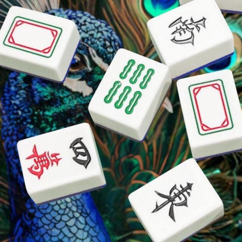 Puede incluir: Seis fichas de mahjong rectangulares blancas con diversas marcas, incluyendo caracteres chinos negros, s&iacute;mbolos verdes de bamb&uacute; y marcos rojos, esparcidas sobre un fondo vibrante de plumas de pavo real iridiscentes.
