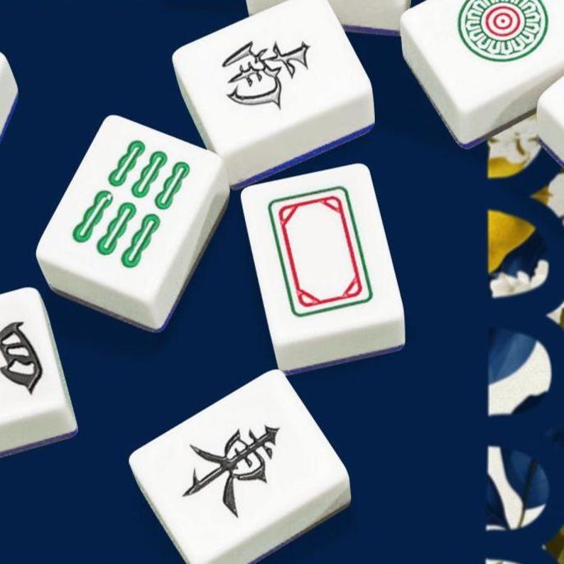 May include: White Mahjong tiles with various green and black symbols and designs. The tiles have a blue border and are arranged on a dark blue background. The game pieces feature different suits and numbers.