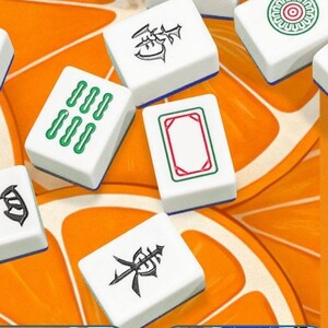 K&ouml;nnte beinhalten: Nahaufnahme mehrerer wei&szlig;er Mahjong-Steine mit verschiedenen Symbolen und Schriftzeichen in Gr&uuml;n, Rot und Schwarz. Die Steine liegen auf einem orangefarbenen Hintergrund, was einen lebendigen und ansprechenden Anblick ergibt.