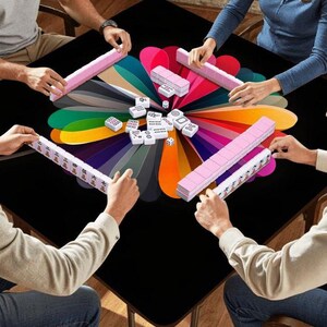 Puede incluir: Una partida de Mahjong en una mesa negra. La mesa tiene un dise&ntilde;o floral colorido en el centro. Las fichas de Mahjong son blancas con s&iacute;mbolos negros, y los soportes son rosas. Tambi&eacute;n se ven dados.