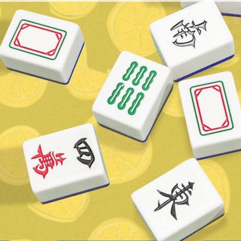 Pode incluir: Pe&ccedil;as de Mahjong brancas com s&iacute;mbolos e marca&ccedil;&otilde;es verdes, vermelhas e pretas. As pe&ccedil;as est&atilde;o espalhadas sobre um fundo amarelo com um padr&atilde;o de lim&atilde;o. As pe&ccedil;as t&ecirc;m bordas azuis.