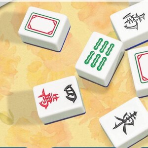 May include: White Mahjong tiles with various symbols and markings in red, green, and black. The tiles have a rectangular shape with blue edges. Some tiles feature sets of green dots, while others display Chinese characters.