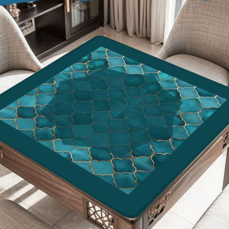May include: A square table cover featuring a teal and dark green quatrefoil pattern with thin gold outlines. The cover has a solid dark teal border and is designed to fit a square table, providing a decorative surface with a geometric motif.