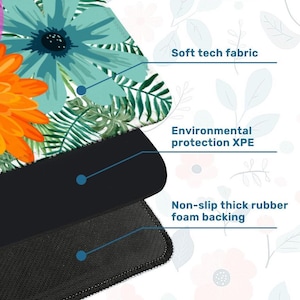 May include: A close-up of a floral mousepad with a white background. The mousepad features a colorful design of blue and orange flowers with green leaves. The mousepad has a soft tech fabric, environmental protection XPE, and a non-slip thick rubber foam backing.