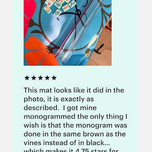 May include: A blue mat with a floral design featuring orange and red flowers and brown vines. The mat has a clear plastic tube and small tiles with symbols. The text on the image says, "This mat looks like it did in the photo, it is exactly as described."