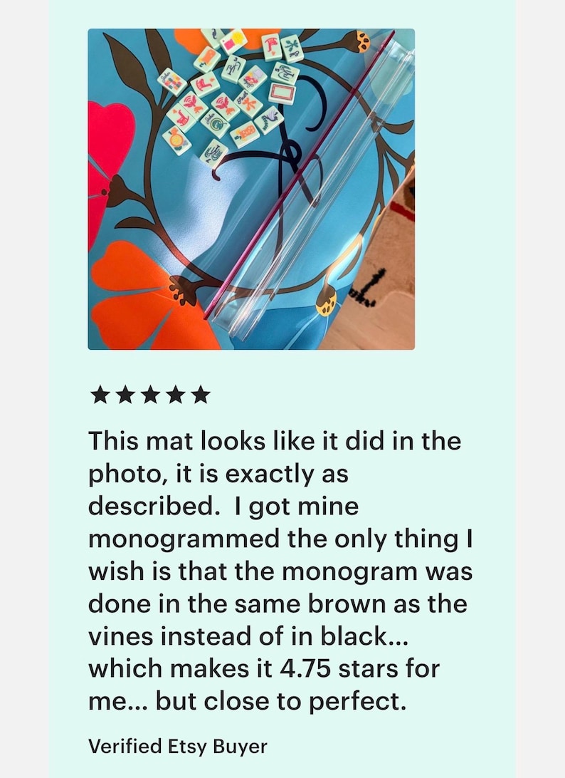 May include: A blue mat with a floral design featuring orange and red flowers and brown vines. The mat has a clear plastic tube and small tiles with symbols. The text on the image says, "This mat looks like it did in the photo, it is exactly as described."