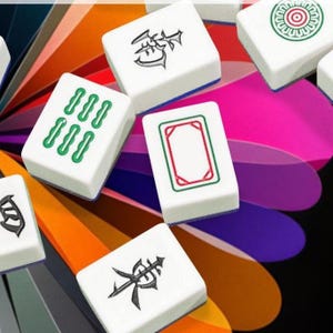 Puede incluir: Un conjunto de fichas de Mahjong blancas con varios s&iacute;mbolos y marcas en verde, rojo y negro. Las fichas est&aacute;n dispuestas sobre un fondo colorido y abstracto, mostrando los componentes del juego.