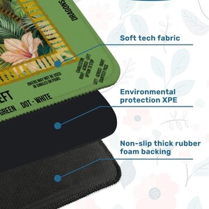May include: A close-up of a multi-layered mousepad. The top layer has a green border with text and a floral design. The middle layer is black, and the bottom layer is a textured black. Text on the mousepad includes "Soft tech fabric" and "Non-slip thick rubber foam backing."