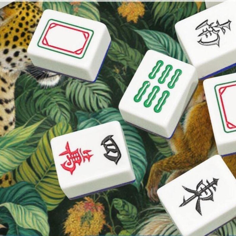 May include: White mahjong tiles with green, red, and black symbols. The tiles are set against a green and white tropical leaf pattern. Some tiles have a red and green border, and blue edges.