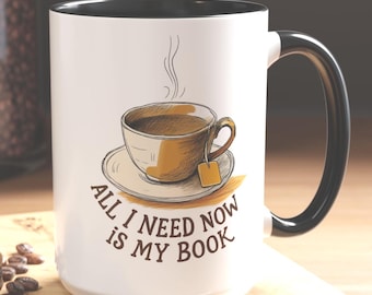 May include: White ceramic mug with a black handle. The mug has a drawing of a cup of tea with steam rising from it and the text "All I need now is my book".