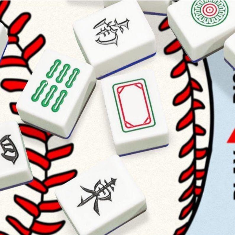 May include: A collection of white rectangular mahjong tiles featuring black Chinese characters, green symbols, and a red-bordered blank tile, scattered across a surface printed with a graphic of a baseball with red stitching and black lines.
