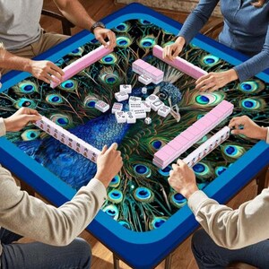 Puede incluir: Una mesa de mahjong cuadrada con un patr&oacute;n vibrante de plumas de pavo real en tonos azul, verde y dorado. Cuatro personas est&aacute;n sentadas alrededor de la mesa, cada una con un soporte de fichas blancas. Hay fichas blancas en el centro.