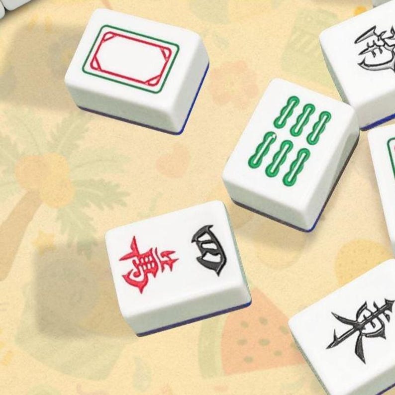 May include: A collection of white rectangular mahjong tiles featuring various engraved symbols. One tile displays a red and green rectangular border, another shows six green bamboo-like shapes, and others feature black and red Chinese characters.