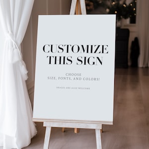 May include: A white sign with black text on an easel. The sign says "Customize this sign. Choose size, fonts, and colors! Images are also welcome."