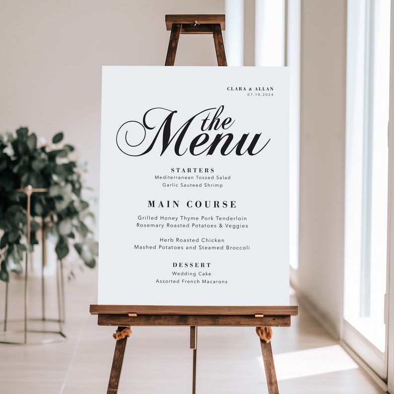 May include: A white wedding menu sign with black text. The menu includes starters, main course, and dessert options. The text reads "Clara & Allan 07.18.2024 The Menu".