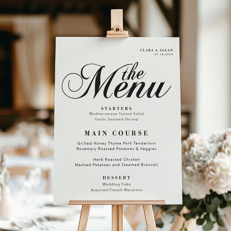 May include: A white wedding menu sign with black text. The menu includes starters, main course, and dessert options. The text reads "Clara & Allan 07.18.2024 The Menu Starters Mediterranean Tossed Salad Garlic Sauteed Shrimp Main Course Grilled Honey Thyme Pork Tenderloin Rosemary Roasted Potatoes & Veggies Herb Roasted Chicken Mashed Potatoes and Steamed Broccoli Dessert Wedding Cake Assorted French Macarons"