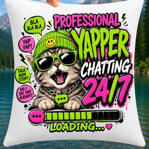 May include: A white square throw pillow featuring a graphic of a tabby cat wearing a green beanie with a smiley face, green sunglasses, and a silver chain. The text reads PROFESSIONAL YAPPER CHATTING 24/7, BLA BLA BLA, YAP YAP!, TALK NON STOP!, DID I SAY THAT ALREADY?, and LOADING...