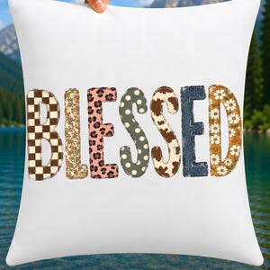 May include: A white square throw pillow featuring the word BLESSED in large capital letters. Each letter has a unique pattern: brown and white checkerboard, floral, pink leopard print, olive polka dot, cow print, denim, and daisy floral.