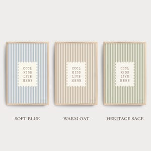 May include: Three framed prints with vertical striped backgrounds in soft blue, warm oat, and heritage sage colors. Each print has a white rectangle with the text "COOL KIDS LIVE HERE".