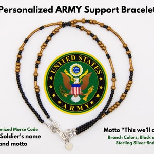 Puede incluir: Un brazalete de cuentas negras y doradas con un cierre y un dije de corazón de plata de ley. El brazalete está personalizado con código Morse, un nombre y un lema. La imagen también incluye el logotipo del ejército de los Estados Unidos.