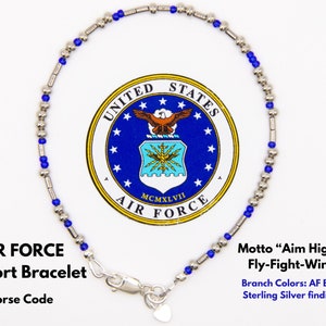 May include: A silver bracelet with blue beads and a heart charm. The bracelet is a Morse code support bracelet for the United States Air Force. The motto "Aim High... Fly-Fight-Win" and branch colours are included in the text.