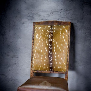 May include: A brown leather chair with a back upholstered in a spotted pattern. The chair has a wooden frame and a brown leather seat. The chair is labeled "Rustic Expressions" with the text "Est. 1985".