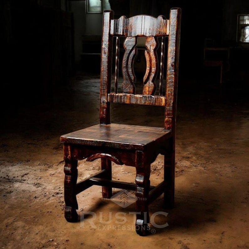 Puede incluir: Una silla de madera r&uacute;stica con respaldo tallado y acabado en marr&oacute;n oscuro. La silla tiene un dise&ntilde;o sencillo con cuatro patas y un asiento ligeramente curvado.