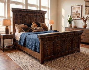 May include: A bedroom featuring a large, intricately carved wooden bed frame with a matching headboard and footboard. The bed is adorned with pillows and a blue blanket. The room includes a rug, nightstands, lamps, and a dresser.