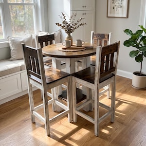 May include: A round wooden dining table with a dark brown stained top and a distressed white base, accompanied by four matching high-back bar stools featuring dark brown seats and distressed white frames, arranged in a dining set configuration.