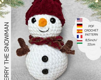 May include: A handmade crochet snowman with a burgundy hat and scarf, black button eyes and a carrot nose. The snowman has brown stick arms and black button details. The text "MERRY THE SNOWMAN" is on the left side.