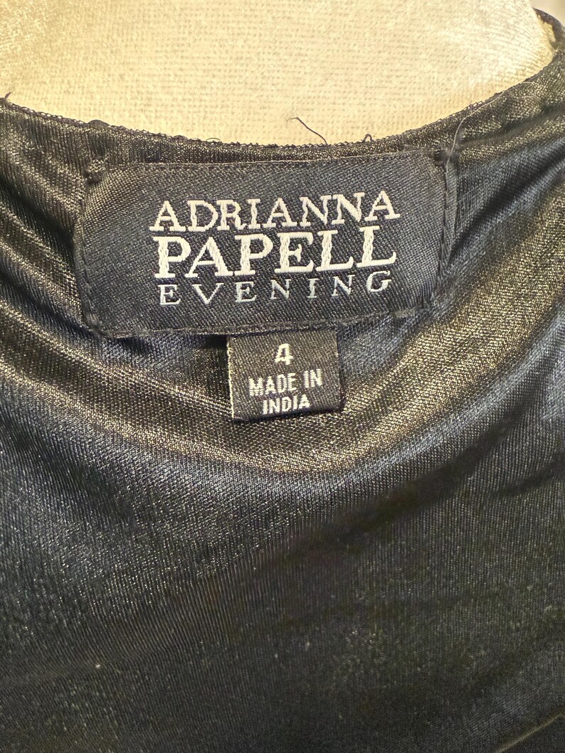 Pu&ograve; includere: Etichetta nera con testo bianco che recita "Adrianna Papell Evening" e un'etichetta bianca pi&ugrave; piccola che recita "4 Made in India".